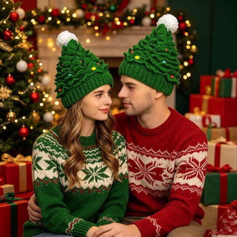 Couple wearing green Christmas tree knit beanies by a decorated tree