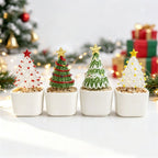 Four mini glass Christmas trees in white ceramic pots