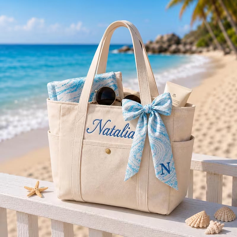 Personalized canvas tote bags embroidered with names on a table at a garden wedding