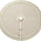 Cream cable-knit tree skirt laid flat with its ties and trunk opening