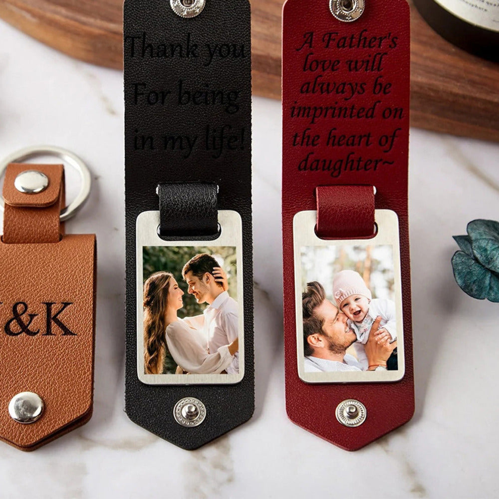 Leather photo keychains engraved with a message, opened to show a family photo