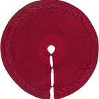 Red cable-knit tree skirt laid flat, showing the trunk opening and three tie closures