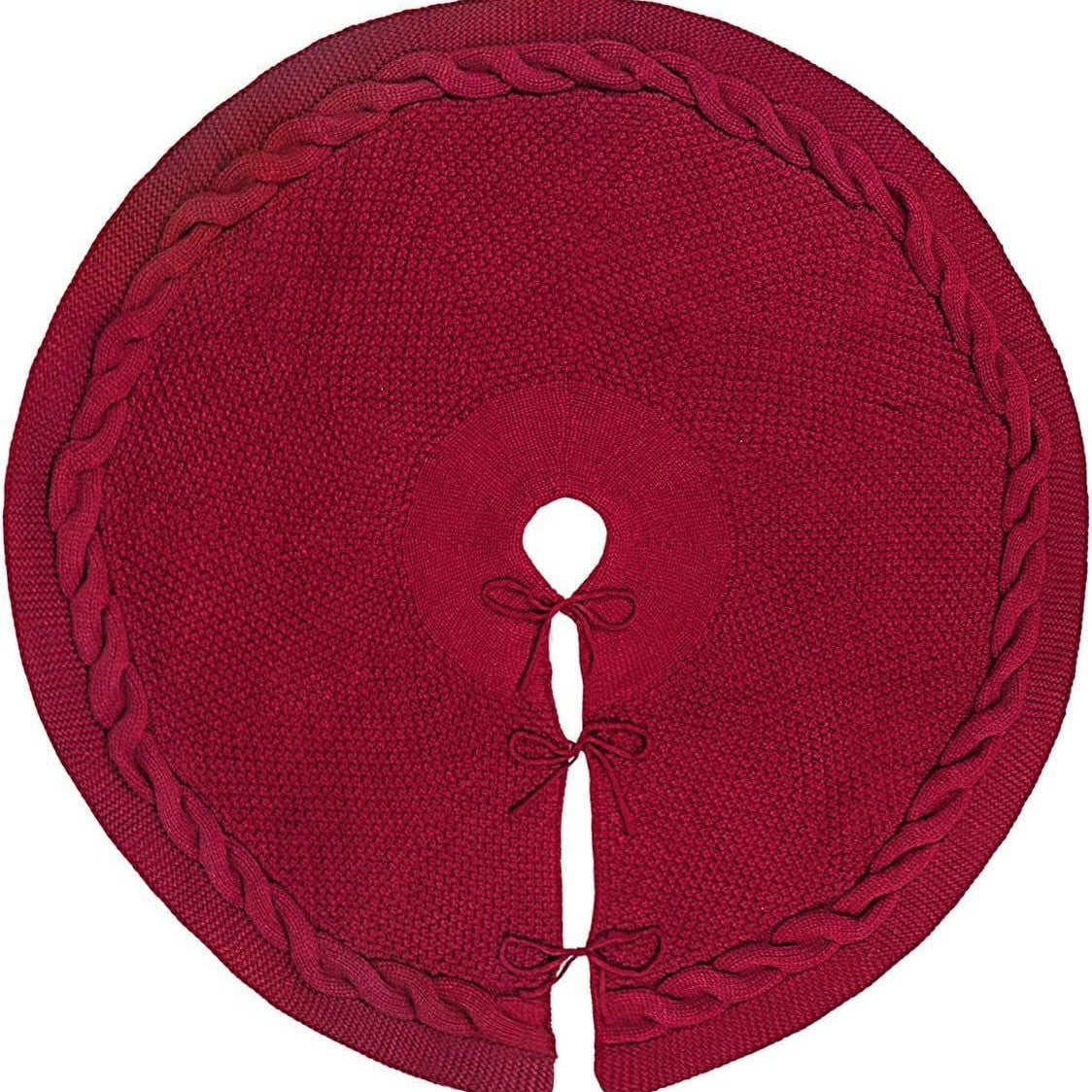 Red cable-knit tree skirt laid flat, showing the trunk opening and three tie closures